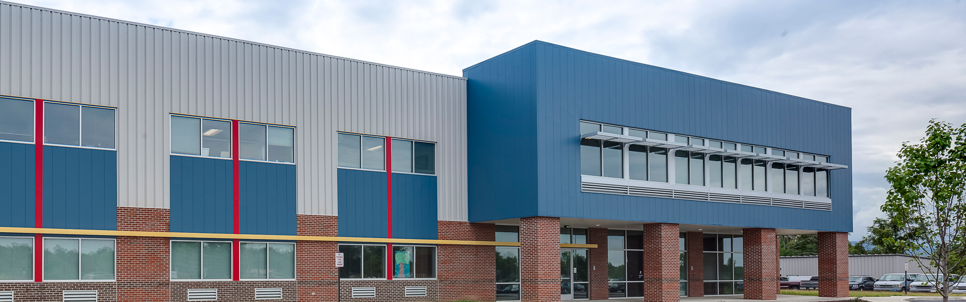 Modern commercial metal building exterior with colored panels and mixed panel facade